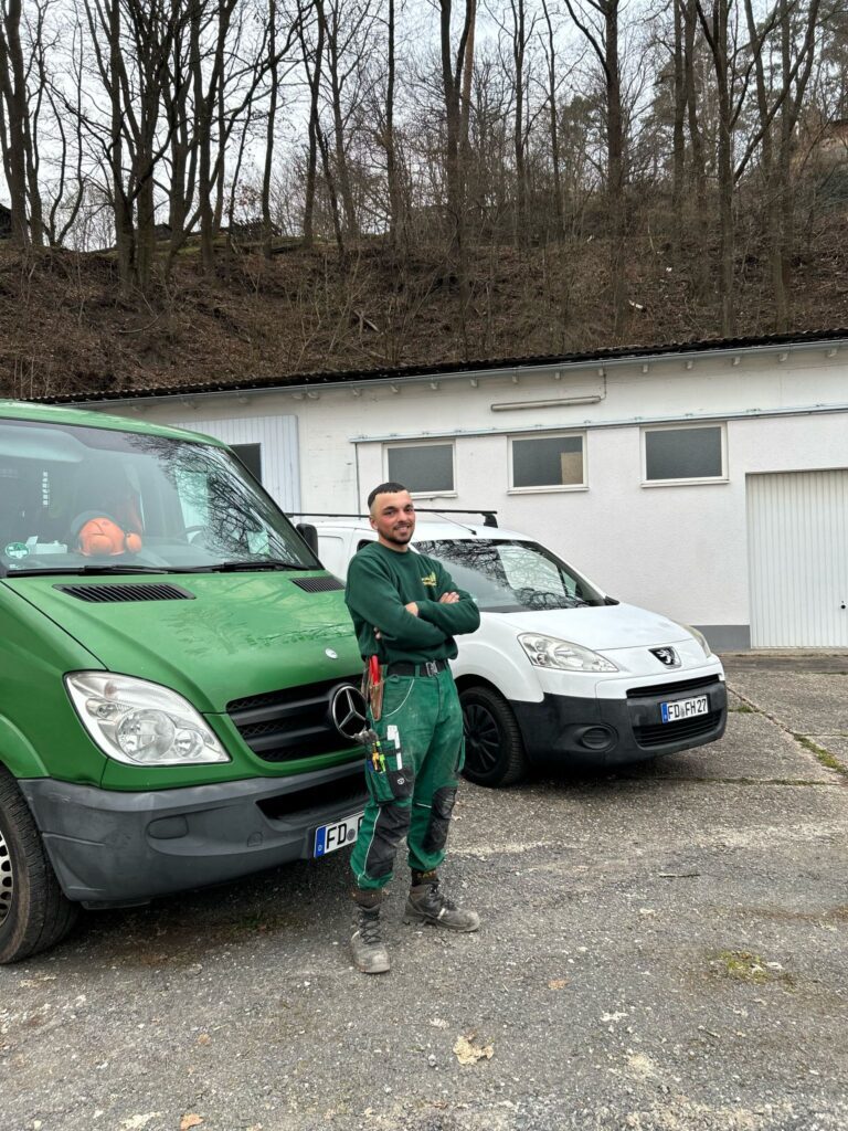 Florjan Hoxhaj vor Servicefahrzeugen